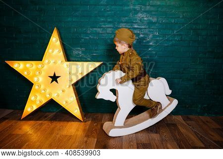 Portrait Of Little Boy Riding A Horse. Children Play With Toys. The Boy Is Preparing To Learn Pony R