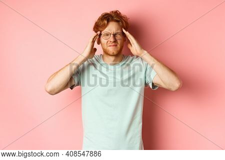 Portrait Of Redhead Man In Crooked Glasses Touching Head And Feeling Dizzy Or Nauseous, Having Hango