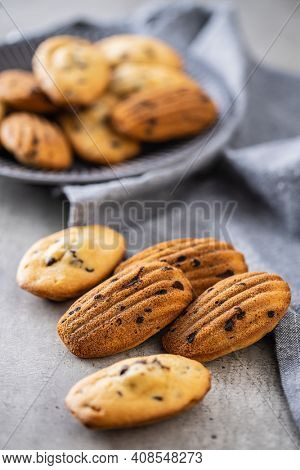 Madeleine with chocolate. Traditional French small cakes on kitchen table.