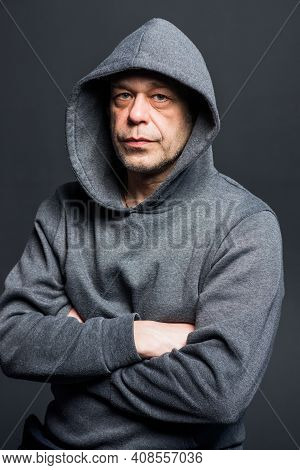 Studio Portrait Of A 40-50-year-old Serious Man In A Gray Hoodie On A Neutral Background, Eyes Direc