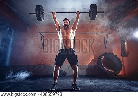 Muscular Fitness Man Doing Deadlift A Barbell Over His Head In Modern Fitness Center. Functional Tra