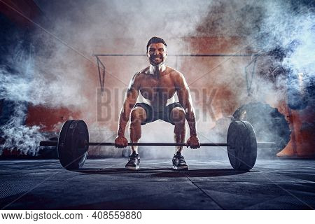 Muscular Fitness Man Doing Deadlift A Barbell Over His Head In Modern Fitness Center. Functional Tra