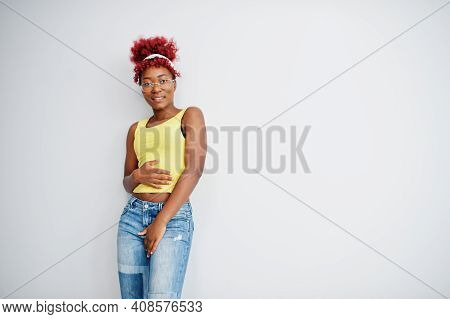 African American Woman In Yellow Singlet And Eyglasses Against White Wall.