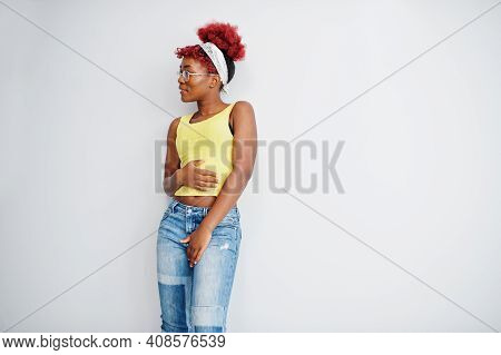 African American Woman In Yellow Singlet And Eyglasses Against White Wall.