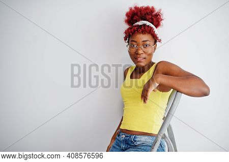 African American Woman In Yellow Singlet And Eyglasses Against White Wall Stand Om Iron Ladder.