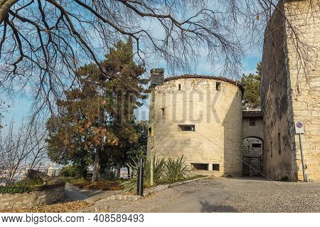 Part Of The Castle Of The City Of Brescia On A Sunny Winter Day. A Viewthrough The Trees. Castello D