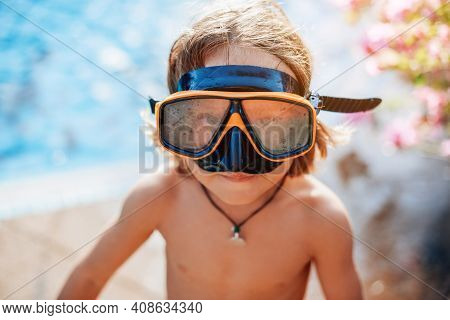 Swimming And Enjoynment. Cheerful Kid With Naked Body Weared With Goggles Looks At Camera In Backgro