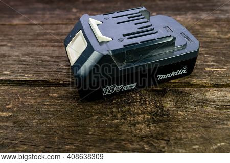 Miercurea Ciuc, Romania- 17 February 2021: Makita Cordless Drill  18 Volt Battery On Aged Pine Wood 