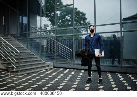 Middle Eastern Entrepreneur Wear Black Face Mask And Eyeglasses Hold Laptop. New Normal Life After C