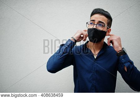 Middle Eastern Entrepreneur Wear Black Face Mask And Eyeglasses Against White Wall. New Normal Life