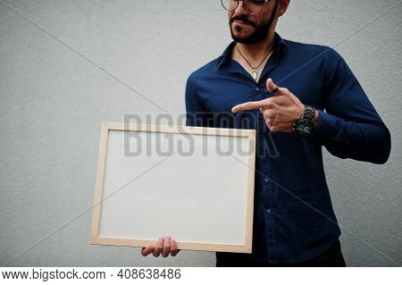 Middle Eastern Man Wear Blue Shirt, Eyeglasses, Hold White Empty Board.