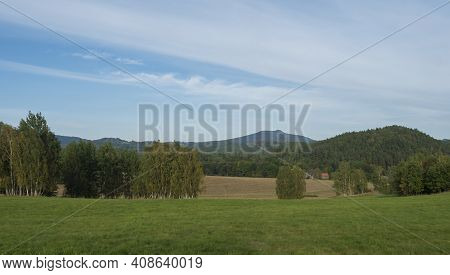 Meadow With Forest, Fields And Hills With Country Houses. Summer Sunny Day, Landscape In Luzicke Hor