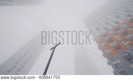 Residential High-rise Buildings In Fog. Action. Bottom View Of High-rise Buildings Shrouded In Thick