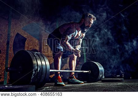 Muscular Fitness Man Preparing To Deadlift A Barbell In Modern Fitness Center. Functional Training. 