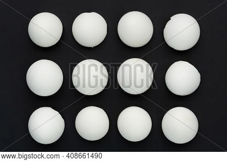 White Eggshells Are Laid Out In Even Rows On A Black Background. The Concept Of Sameness, Equality A