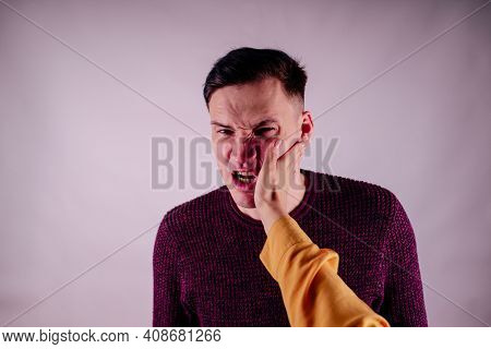 Crop Person Slapping Scared Man In Face. Emotional Male Getting Slapped In Face While Shouting With