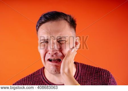Man Getting Slapped On Orange Background. Unhappy Scared Man Getting Slapped Standing On Orange Back