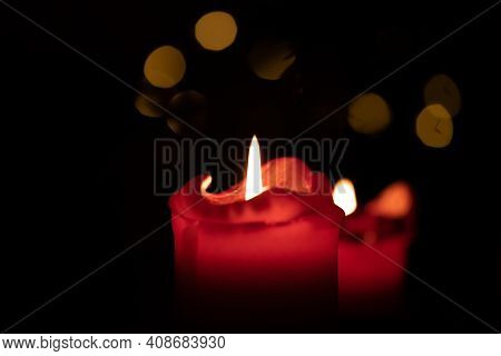 Red Round Candle Burning With Bokeh Lights Background