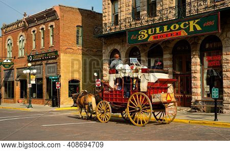 Deadwood, Sd, Usa - September 15, 2020: An Old-fashioned Stagecoach Carries Tourists Past The Old Bu