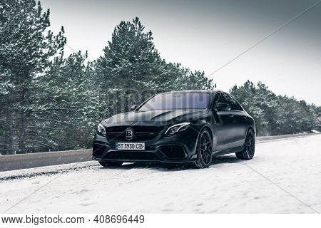 Kherson, Ukraine - February 2021. Powerful Mercedes-amg E63s Brabus 800 In A Black Color On The Empt