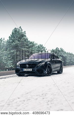 Kherson, Ukraine - February 2021. Powerful Mercedes-amg E63s Brabus 800 In A Black Color On The Empt