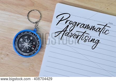 Top View Of Magnetic Compass And Notebook Written With Text Programmatic Advertising.