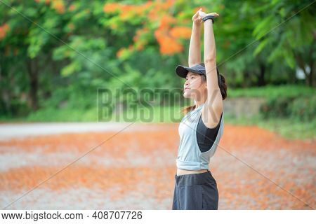 Portrait Of Runner Woman Doing Stretching And Warming Up Her Body Before Running In The Park. The Be