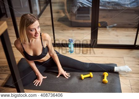 Female Athlete Spreading Her Legs While Having Workout