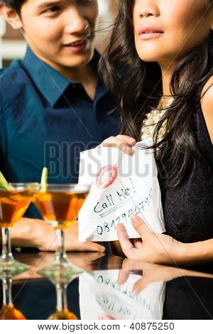 Donna asiatica seduce l'uomo nel ristorante e gli dà il suo numero su un tovagliolo