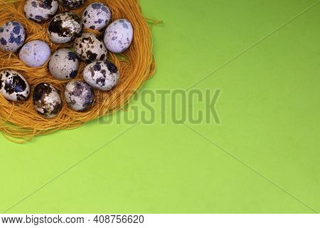 Quail Eggs In An Impromptu Nest Made Of Threads On A Green Background, Copy Space. Decoration For Th