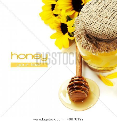 Topf voll Honig und Honig-Stick über weiß und Blumen. Mit leicht abnehmbaren Beispieltext