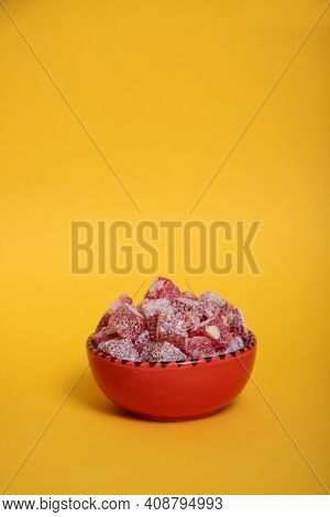 Red Bowl Of Rahat Lakoum Isolated On Yellow Background. Turkish Sweet Concept. Vertical Image. Image
