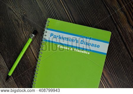 The Book Of Parkinson's Disease Cause & Statistics Isolated On Wooden Table. Medical Or Healthcare C