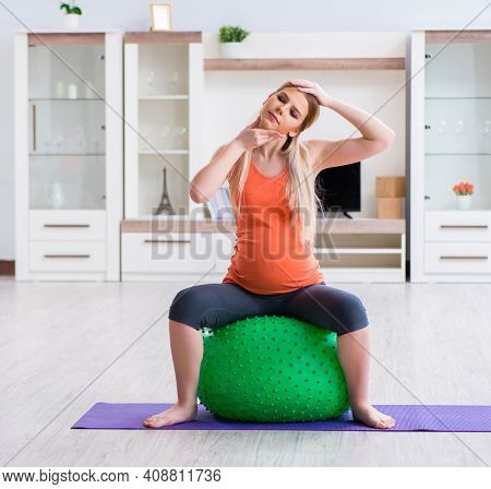 Young woman preparing for birth exercising at home