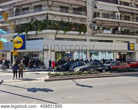 Thessaloniki, Greece February - 18 2021: Crowd With Covid-19 Masks Queuing Outside Super Market. Lar