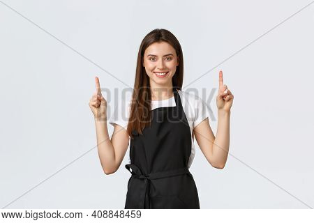 Small Business, Employees And Coffee Shop Concept. Confient Pretty Barista In Black Apron Pointing F