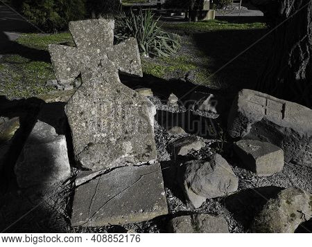 Cross. Headstone At A Catholic Christian Cemetery. A Lopsided Stone Monument. Unknown Grave In The R