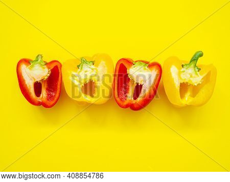 Red And Yellow Bell Peppers Sliced By The Half With Seeds Isolated In Yellow Background Viewed From 