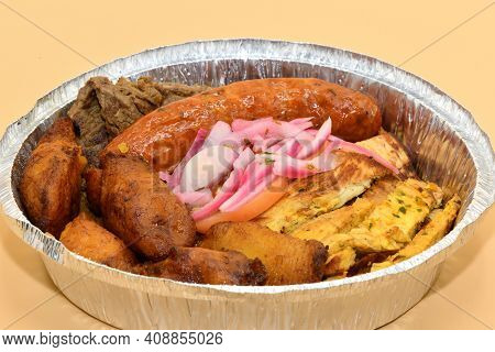 A Columbian Meat Plater Made Of Sausage, Steak, Chicken, Plantains, And Pickled Onions.
