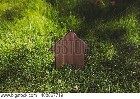 Green Home And Eco-friendly Construction, House Icon On Green Grass Lawn Under The Sun With Garden B