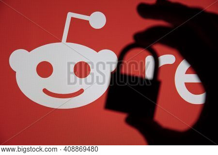 London, Uk - February 2021: Silhouette Of Padlock Against Reddit Logo