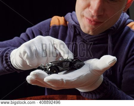 Gomel, Belarus - February 16, 2021: Portrait Of A Collector Of Retro Car Models On A Black Backgroun