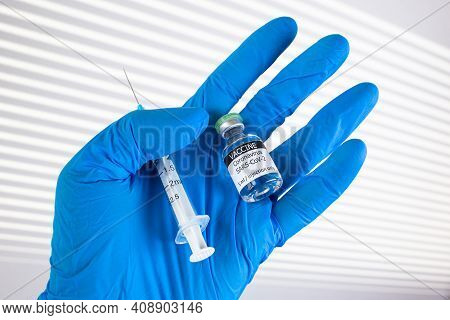 Coronavirus Covid-19. Vial With Single Dose Of Vaccine. Doctor's Hand In Latex Medical Gloves Hold T