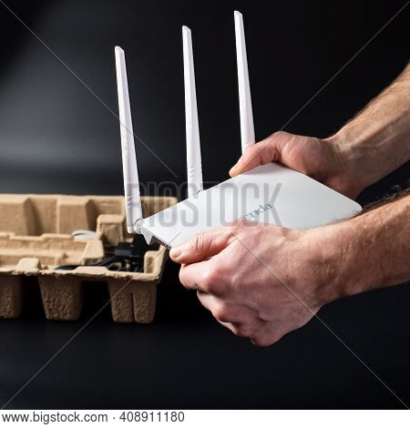 Male Hands Unpacking Brand New Wifi Router On Black Background.