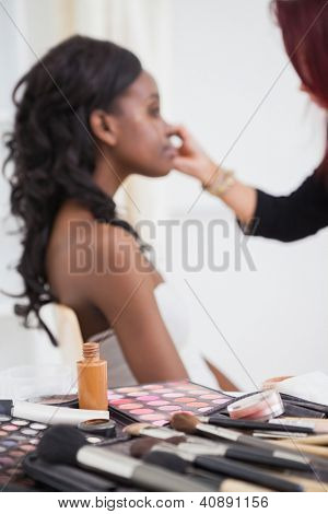 Mesa llena de maquillaje con la mujer que hizo por maquillaje Artisitico