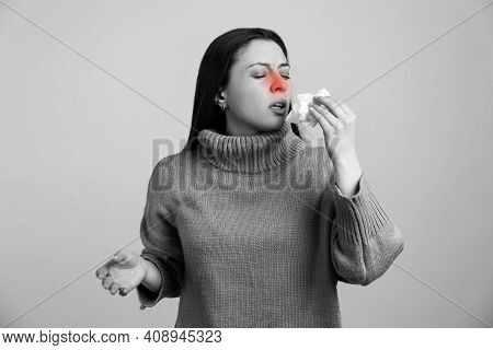 Young Woman With Tissue Sneezing On Light Background, Toned In Black And White. Runny Nose