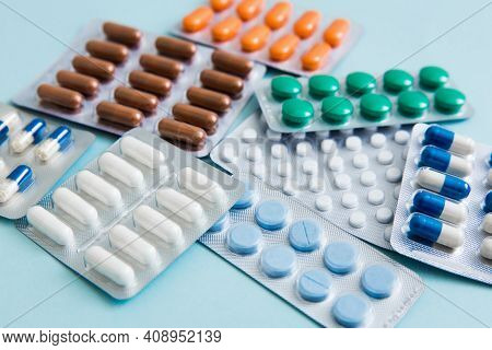 Different Tablets, Pills, Capsule Medicines Blister Packs, On Blue Background. Health Care Concept. 