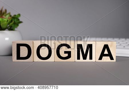 Dogma. Text On Wood Cubes On Gray Background