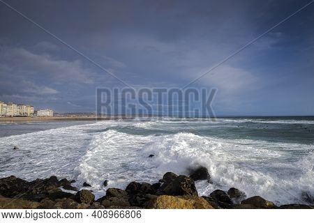 Surfing In The Costa Da Caparica Beach, A Famous Place For Water Sports In Portugal.