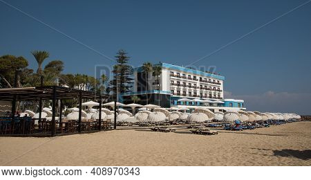 Famagusta, Cyprus - September 15 2016: Palm Beach With Beach Umbrellas And Tourists At A Modern Beac